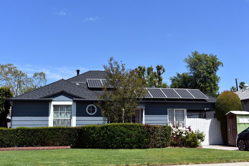 modern blue green house with solar panels in california